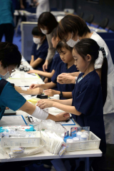 看護師のブースで包帯を巻く子ども(30日午前10時20分ごろ。佐藤有将通信員撮影)