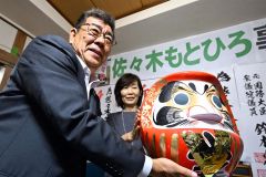 だるまにＶの字を掲げる佐々木氏と曙美夫人（３０日午後９時５０分ごろ、須貝拓也撮影）