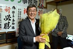 支援者から花束を受け取り笑顔を見せる佐々木氏（３０日午後９時５０分ごろ、須貝拓也撮影）