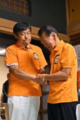 涙を流す後援会の大和田和盛会長（右）と握手する編田氏（３０日午後１０時ごろ、塩原真撮影）