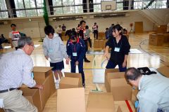 グループで協力して段ボールベッドを作る参加者（３１日午前１０時２０分ごろ）