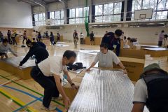 グループで協力して段ボールベッドを作る参加者