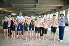 自己記録更新を目指して力泳し１位に輝いた児童と町水泳協会のメンバーら（前列右端は伊藤会長）