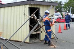 土砂崩れで倒壊した土砂に埋まった住宅の中から負傷者を救出する訓練を行う参加者ら