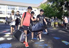 大きなバッグを手に学校を出発する児童（３日午前７時すぎ、帯広小学校で。塩原真撮影）