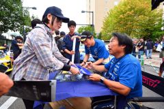 ラリーショーで、ファンのサインに応じる新井敏弘選手（右手前）＝金野和彦撮影