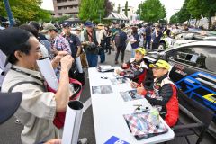 ラリーショーで、笑顔で写真撮影に応じる勝田範彦選手（右手前）と保井宏隆選手（同２人目）＝金野和彦撮影