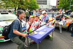 ラリーショーで、ファンと記念写真に応じる鎌田卓麻選手（左から２人目）と松本優一選手（同３人目）＝金野和彦撮影