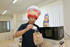 バターしょうゆ味のフレーバー「フレーフレー」を実演する前田社長
