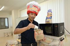 バターしょうゆ味のフレーバー「フレーフレー」を実演する前田社長