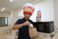 バターしょうゆ味のフレーバー「フレーフレー」を実演する前田社長