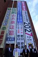 音更町役場本庁舎の壁面に設置された懸垂幕の前で野口兄妹（左から２人目が佳祐さん、右から２人目が紗英さん）のインターハイの活躍を祝福する小野町長（右）と福地教育長（左）