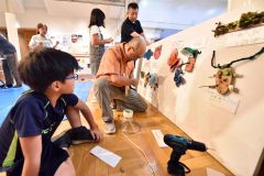 子どもたちの「生きもの」をボードに固定していく堀川さん（中央）