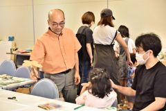 子どもの作品を褒める堀川さん（左）