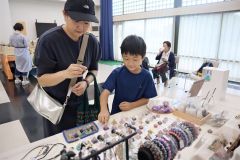 天然石と雑貨のブースで品定めする親子ら