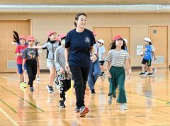 講師の石澤さんと一緒にウオーミングアップに取り組む児童ら