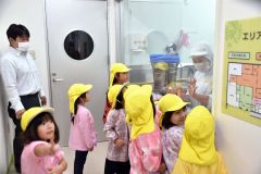 ガラス越しに調理室を見学する園児