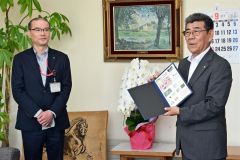 （写真左から）豊頃郵便局の松井局長からフレーム切手を受け取った佐々木町長
