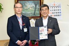 （写真左から）豊頃郵便局の松井局長からフレーム切手を受け取った佐々木町長