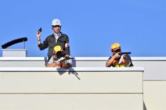 建物の上から猟銃を構えるハンターと警察官（金野和彦撮影）