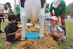 牛の模型で乳搾りを体験する子どもたち（午前１０時２０分ごろ）