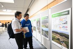 会場に設置されたパネルを眺める来場者（１５日午前１１時ごろ）