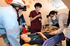 患者を搬送し、状態を確認する職員（長尾悦郎通信員撮影）