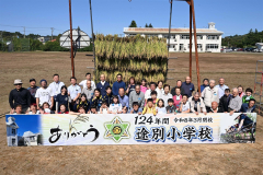 稲刈り体験後に集合写真におさまる途別小の児童ら（１６日、須貝拓也撮影）