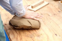 体重をかけながら粘土をこねていく参加者たち。思って以上に力が必要で大人でも苦労していた