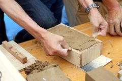 表面が滑らかなれんがになるよう、粘土の無駄な部分を針金を使って削り取る