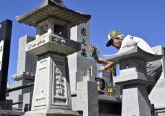 依頼を受け墓の清掃や供花をするシルバー人材センターの会員（１９日、帯広市のつつじヶ丘霊園で。塩原真撮影）