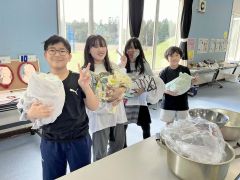 赤ちゃんに見立てたお米の袋を抱っこする児童（町保健福祉課提供）