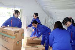 段ボールベッドを組み立てる中学生