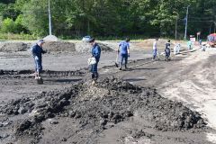 町道や歩道に溜まった汚泥をかき出す町職員