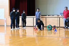 秋山教授（右）や田中特任講師（中央奥）が見守る中。エアロケット打ち上げに臨む生徒たち