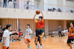 高校生相手にシュートを狙う中学生選手（赤色ウエア）