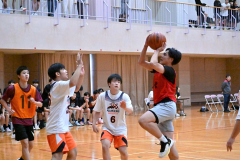 高校生相手にシュートを狙う中学生選手（赤色ウエア）