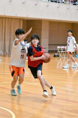 高校生相手にゴールへドライブする中学生選手（赤色ウエア）