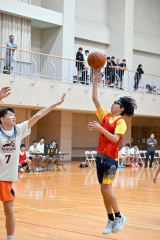 高校生相手にシュートを狙う中学生選手（赤色ウエア）