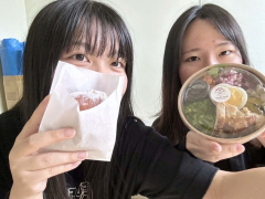 購入した特製のサラダと揚げパンを手にする学生
