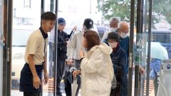 開店を待ちわびた来店客がスタッフに迎えられた