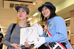 サイン色紙を手にし、角田選手と記念撮影を行う来場者（２７日午前１０時５０分ごろ、須貝拓也撮影）