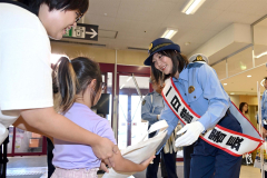 来場者に防犯グッズを手渡す角田選手（２７日午前１０時２０分ごろ、須貝拓也撮影）