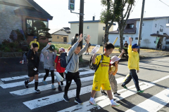 安全確認して歩行者と一緒に横断歩道を渡る団員（右端）