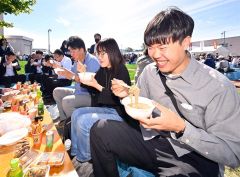 並んで買い求めたそばを食べ笑顔の来場者（午前１０時２０分ごろ、塩原真撮影）