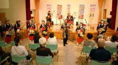 家元の舘岡さん（前列右から３人目）を招いてスコップ三味線を奏でる出演者ら（前列右から２人目が高田代表）