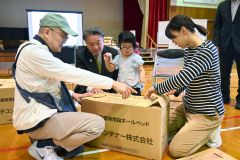 協力して段ボールベッドを組み立てる参加者ら