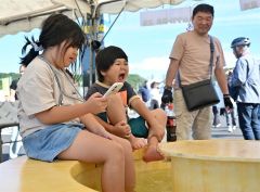 トムラウシ温泉の足湯が登場。ほんのり熱めのお湯加減に驚く子ども