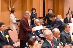 田中大会長（右）から表彰状を受け取る豊頃町の高野さん