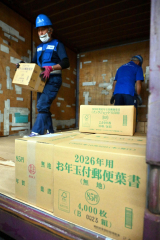 コンテナから次々と降ろされる年賀はがきが入ったダンボール箱（２日午前９時ごろ。帯広郵便局で。金野和彦撮影）